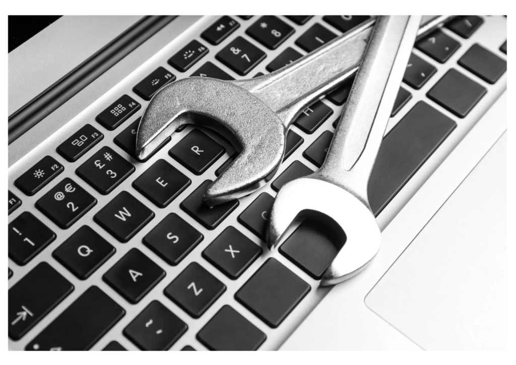 Ferramentas de conserto sobre o teclado de um notebook, representando os serviços de assistência técnica especializada da GR Computadores.