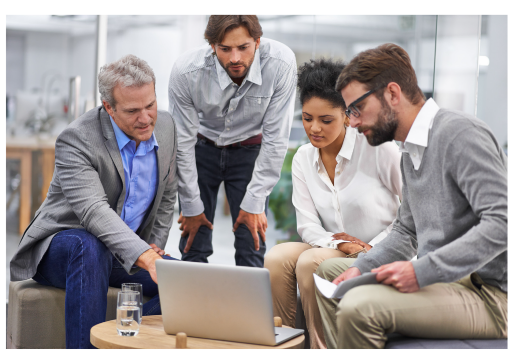Equipe da GR Publicidade em reunião de consultoria de marketing digital com cliente, analisando o desempenho de campanhas em um laptop.
